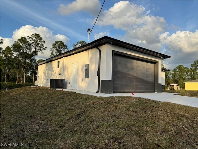 view of property exterior with a garage, a yard, and central AC unit