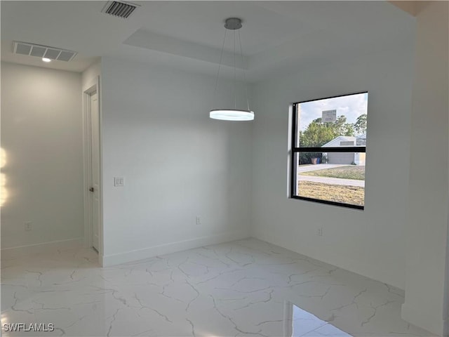 spare room with a tray ceiling