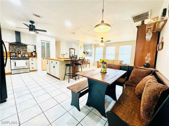 dining space featuring light tile patterned floors, visible vents, and a ceiling fan