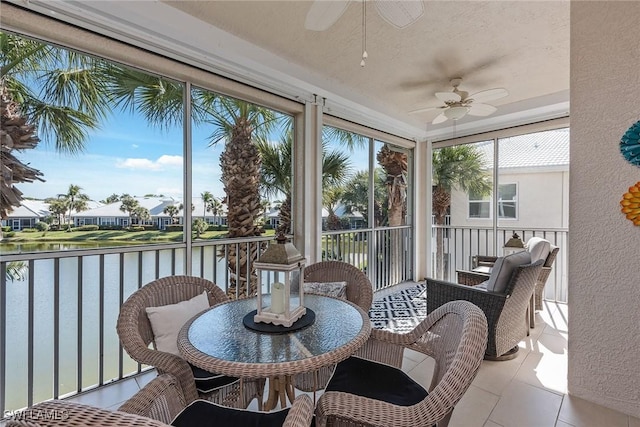 sunroom / solarium featuring a water view and ceiling fan