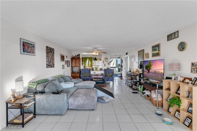 living room with light tile patterned floors, a textured ceiling, and ceiling fan