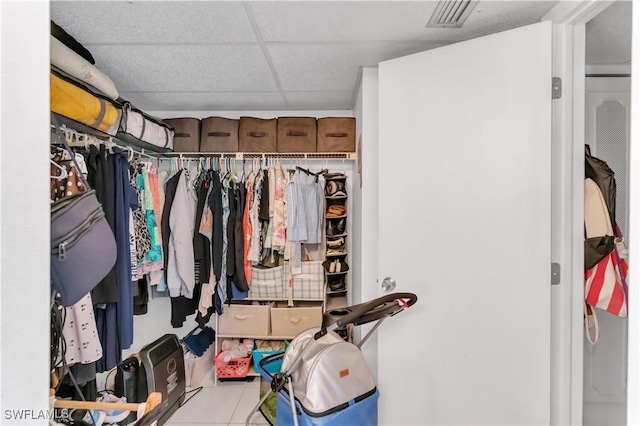 walk in closet featuring light tile patterned floors and a drop ceiling