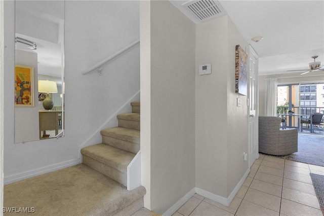 stairway with tile patterned floors and ceiling fan