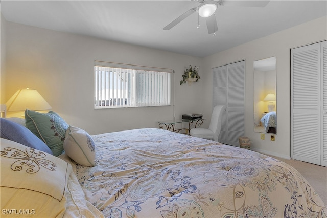 carpeted bedroom with two closets and ceiling fan