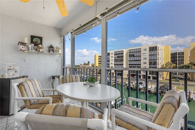 balcony with a water view and ceiling fan