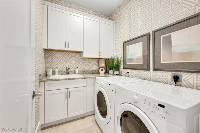 clothes washing area with cabinets, sink, and washer and clothes dryer