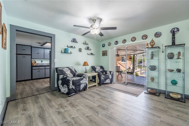 sitting room with ceiling fan and light hardwood / wood-style flooring