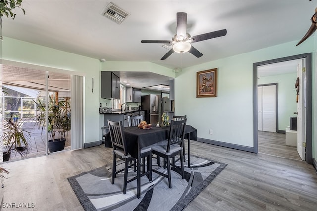 dining space featuring ceiling fan, sink, and light hardwood / wood-style floors