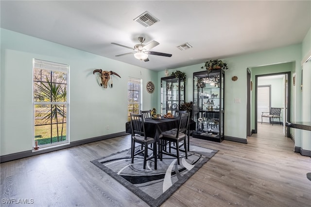 dining room featuring light wood-type flooring, a healthy amount of sunlight, and visible vents