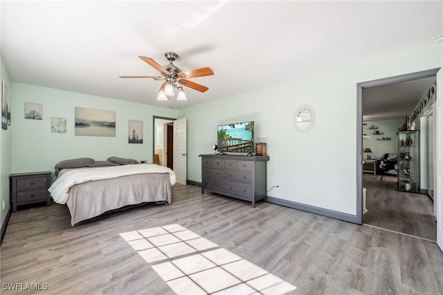 bedroom with light wood-type flooring, ceiling fan, and baseboards