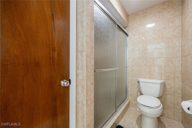 bathroom with walk in shower, toilet, tile patterned flooring, and tile walls