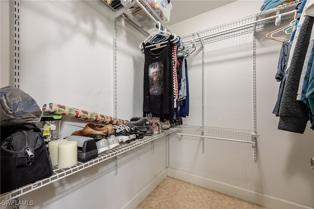 walk in closet with light tile patterned floors