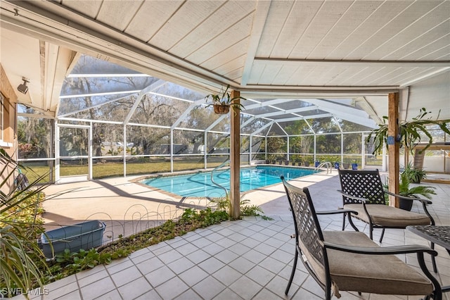 view of pool with a lanai, a mountain view, and a patio