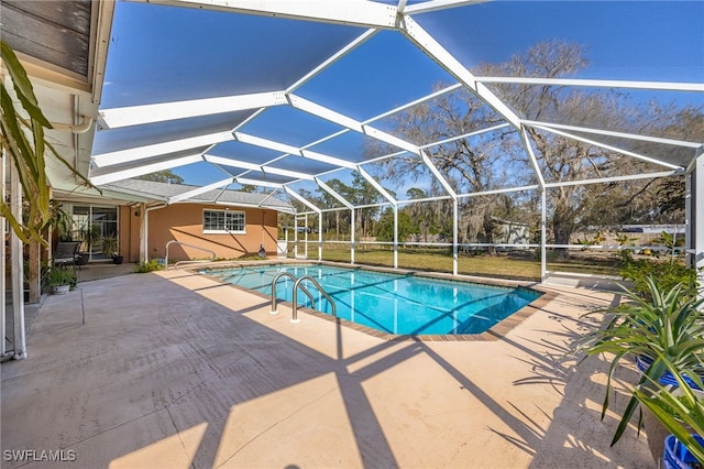 outdoor pool with a patio area and glass enclosure