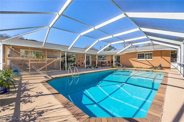 view of pool with a patio area and glass enclosure