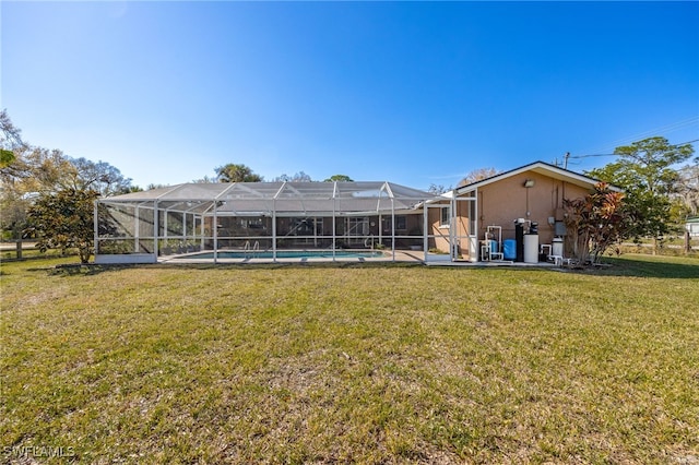 rear view of property featuring glass enclosure, a lawn, and an outdoor pool