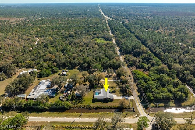 bird's eye view with a wooded view