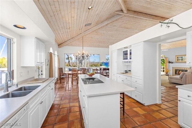 kitchen featuring white cabinetry, sink, a center island, and a kitchen bar