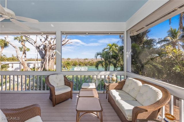 sunroom featuring a water view and ceiling fan