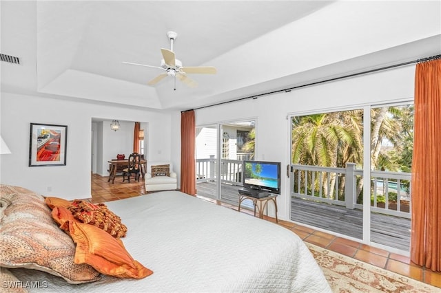 tiled bedroom with access to outside, ceiling fan, and a tray ceiling