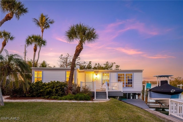 view of front of property with a yard and a boat dock