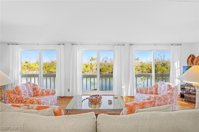 sunroom / solarium with a water view and a healthy amount of sunlight