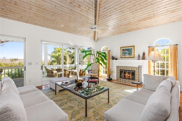 living room featuring ceiling fan, a premium fireplace, and wooden ceiling