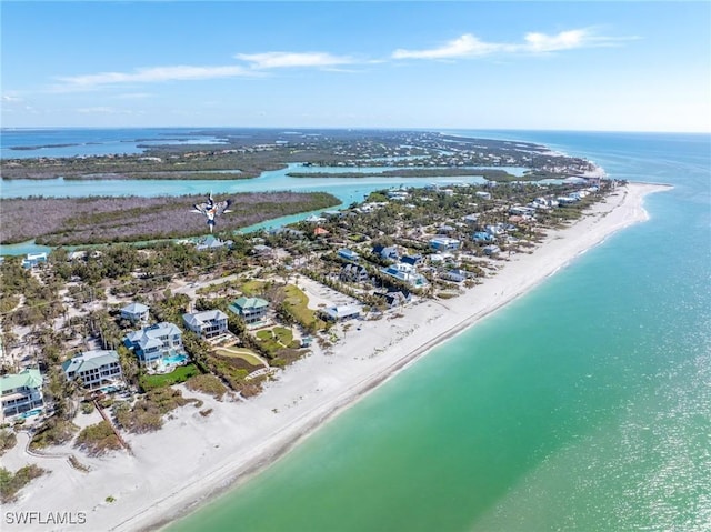 drone / aerial view featuring a beach view and a water view