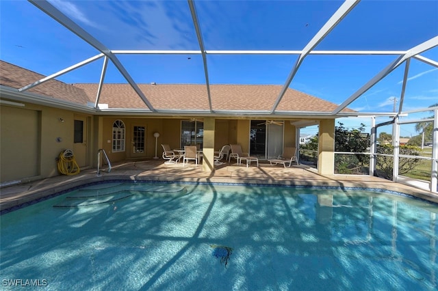 view of pool with a patio and glass enclosure