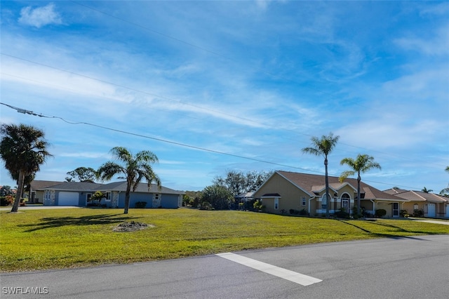 ranch-style home with a garage and a front lawn