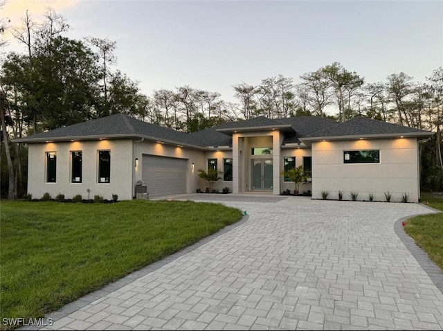 prairie-style house with a garage and a lawn