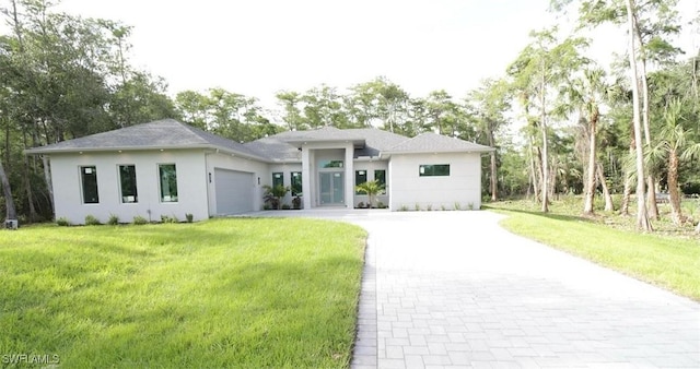 prairie-style home with a garage and a front lawn