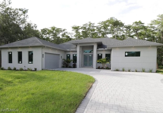 prairie-style home with a garage and a front lawn