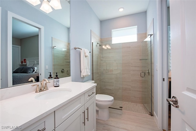 bathroom with vanity, a shower with shower door, and toilet