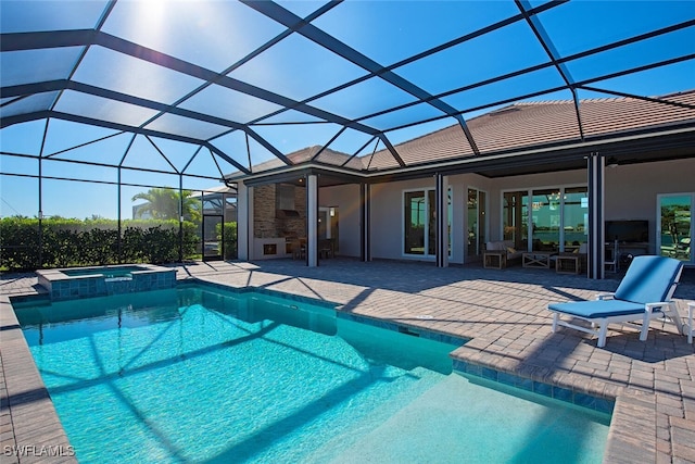 view of pool with an in ground hot tub, a patio, and glass enclosure