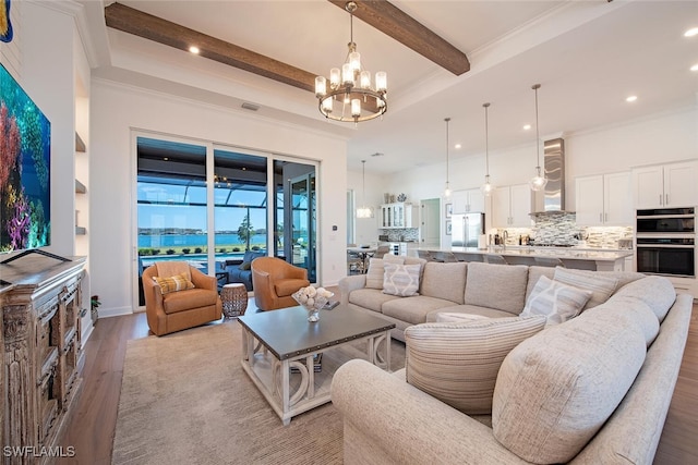 living room featuring crown molding, beam ceiling, light hardwood / wood-style floors, and an inviting chandelier