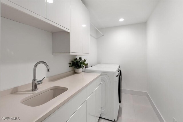 laundry area featuring cabinets, sink, washing machine and dryer, and light tile patterned floors