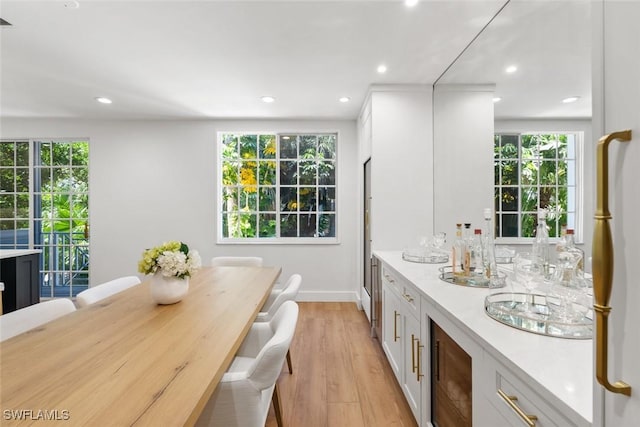 kitchen with light hardwood / wood-style floors, beverage cooler, and white cabinets