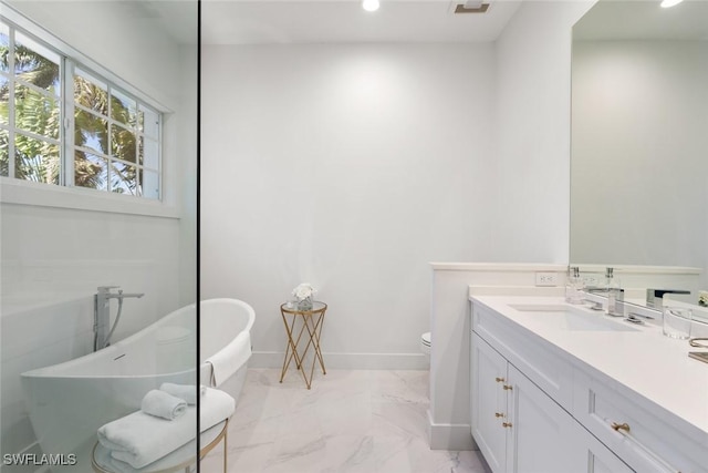 bathroom featuring toilet, vanity, and a bath