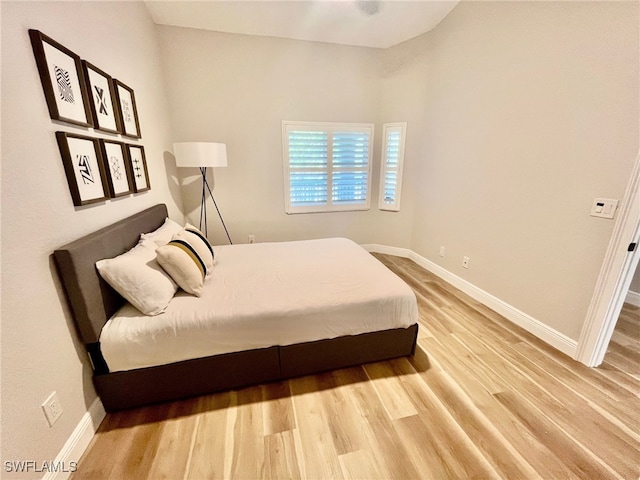 bedroom featuring baseboards and wood finished floors