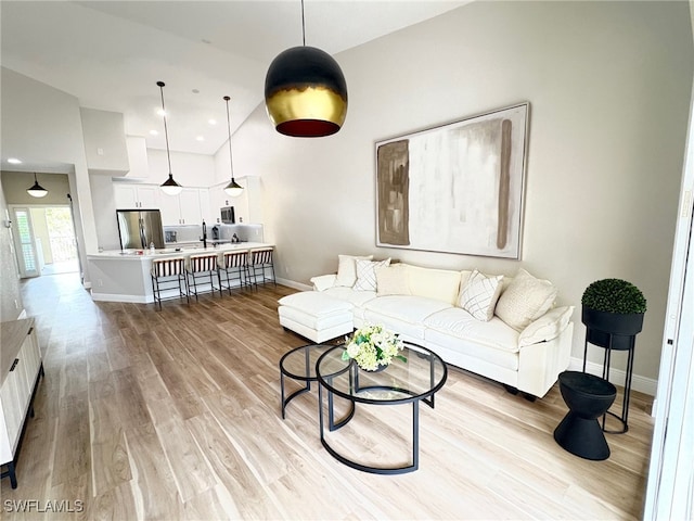 living room with light wood-style floors, recessed lighting, and baseboards