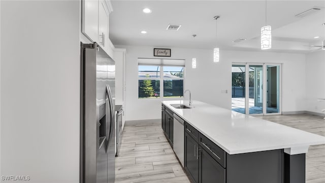 kitchen with stainless steel appliances, light wood-type flooring, visible vents, and a sink