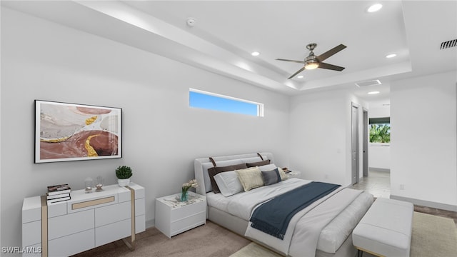 bedroom featuring a tray ceiling, light carpet, baseboards, and recessed lighting