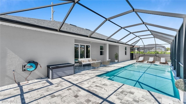 pool with ceiling fan, a patio, outdoor lounge area, and glass enclosure