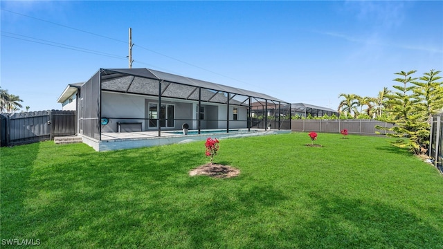 rear view of property featuring a lanai, a fenced backyard, a lawn, and a fenced in pool