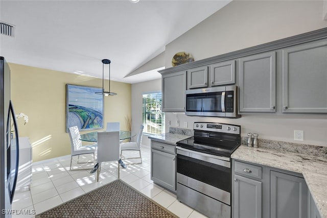 kitchen with light tile patterned floors, gray cabinetry, hanging light fixtures, stainless steel appliances, and vaulted ceiling