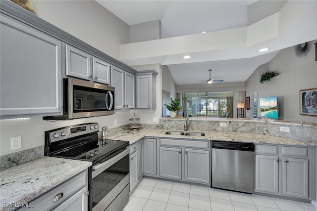 kitchen with gray cabinets, light stone countertops, appliances with stainless steel finishes, and sink