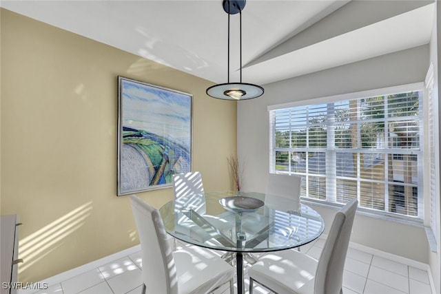 tiled dining area featuring vaulted ceiling