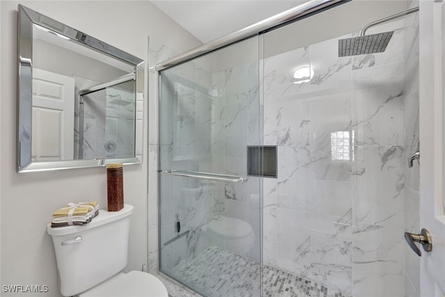 bathroom with a shower with shower door and toilet