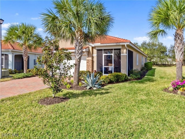 view of front of property featuring an attached garage, a tile roof, decorative driveway, a lawn, and stucco siding